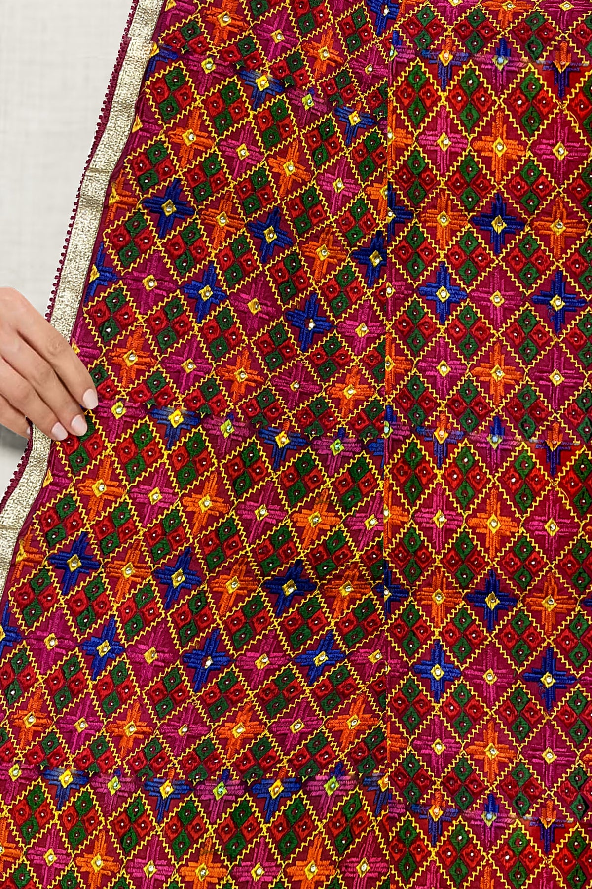 Rangoli Charm Phulkarireflects the vibrant magenta base and multicolor embroidery, reminiscent of a traditional rangoli design, full of color and cultural richness.