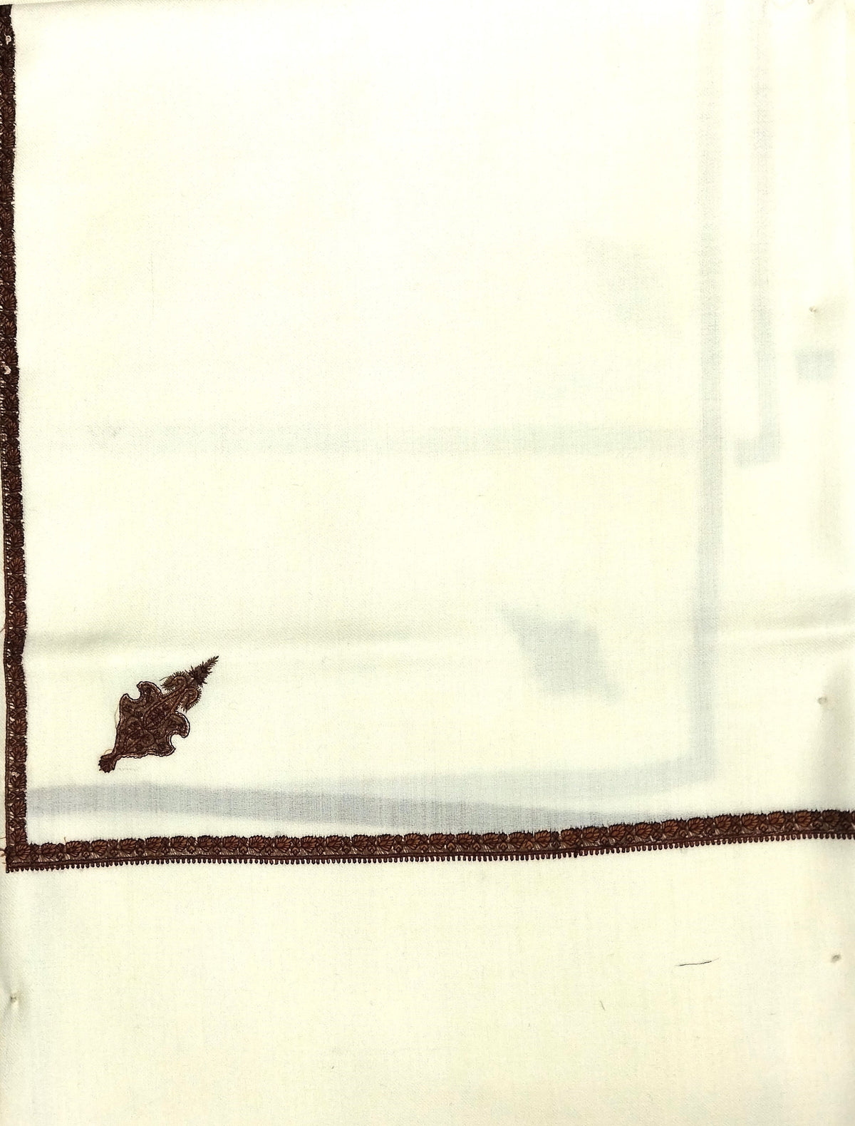White fabric with brown embroidery on a white background
