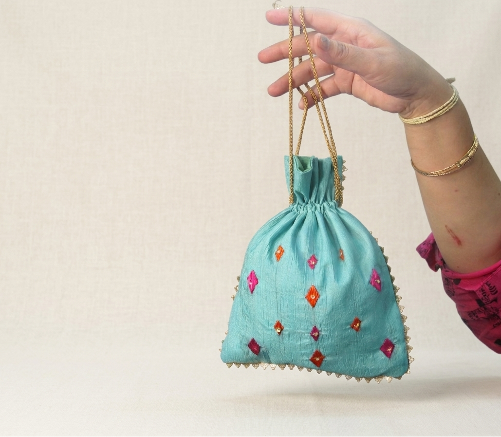Phulkari hand embroidered potli bag with traditional floral design and golden lace detailing