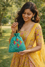 Handcrafted teal Phulkari embroidered potli bag with multicolor geometric floral design, golden lace border, and drawstring closure, traditional Punjabi ethnic accessory